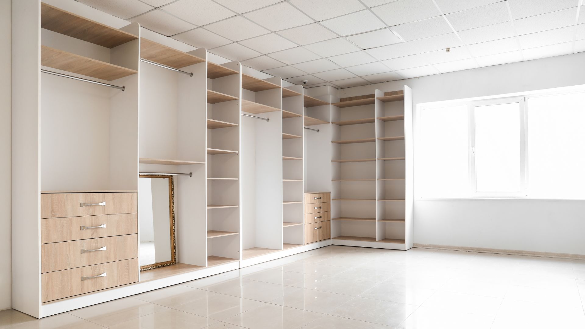 Floor-to-ceiling custom built-in wardrobe with timber drawers, hanging rails and shelving installed wall-to-wall in a Cape Town bedroom by SK Projects & Investments